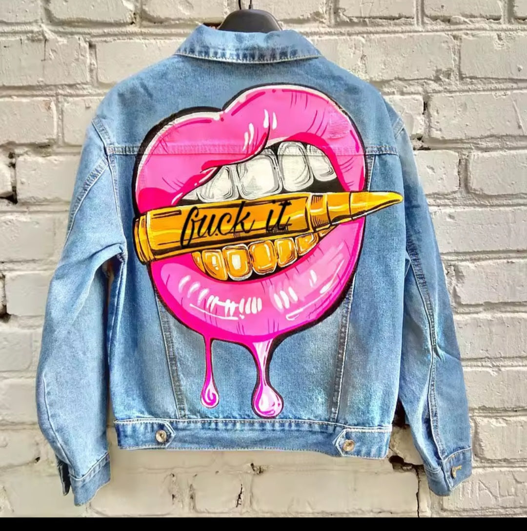 Denim jacket with a graphic design of pink lips and a dart on a brick wall background