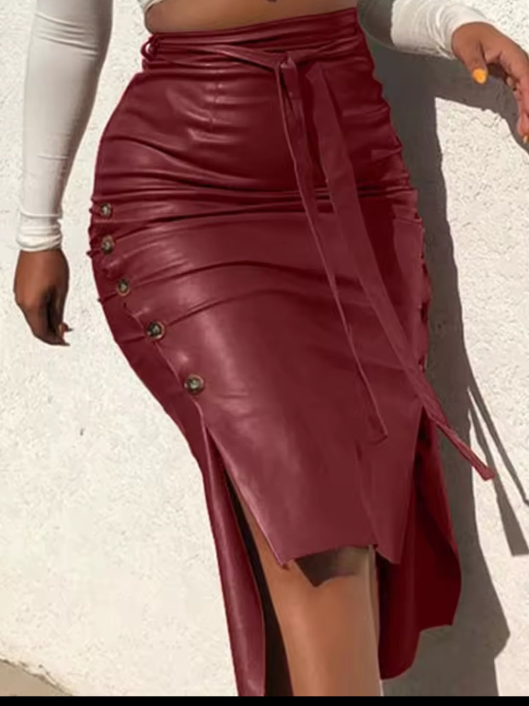 Maroon leather skirt with button details on a light background