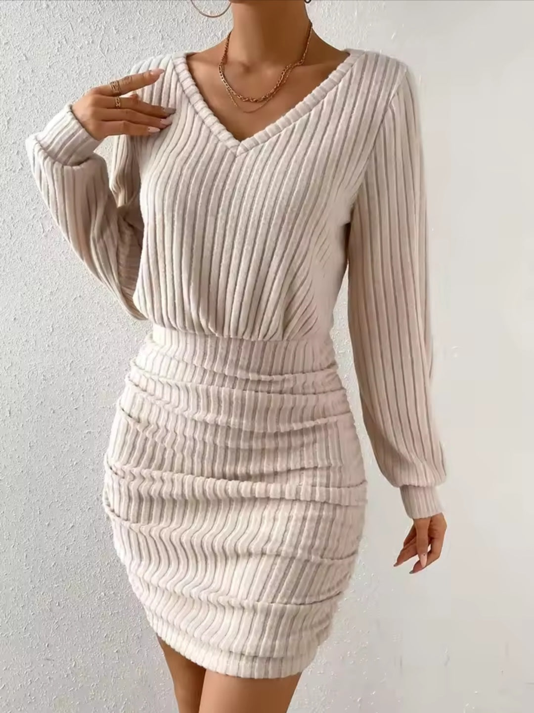 Beige ribbed dress worn by a person on a white background