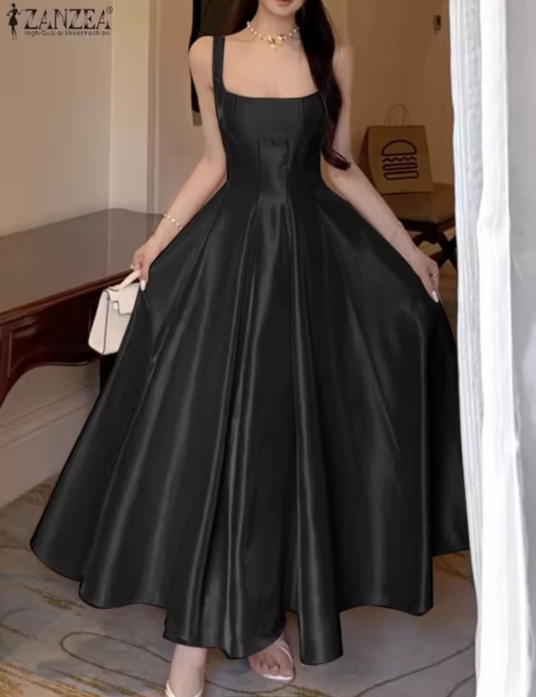 Woman wearing a black satin dress in an indoor setting