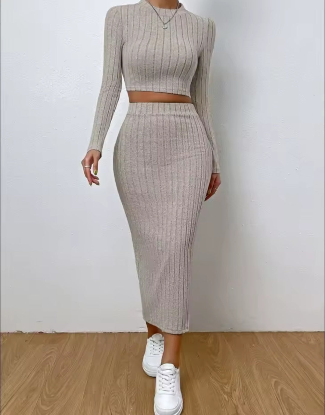 Person wearing a beige ribbed knit two-piece set with white sneakers on a plain background