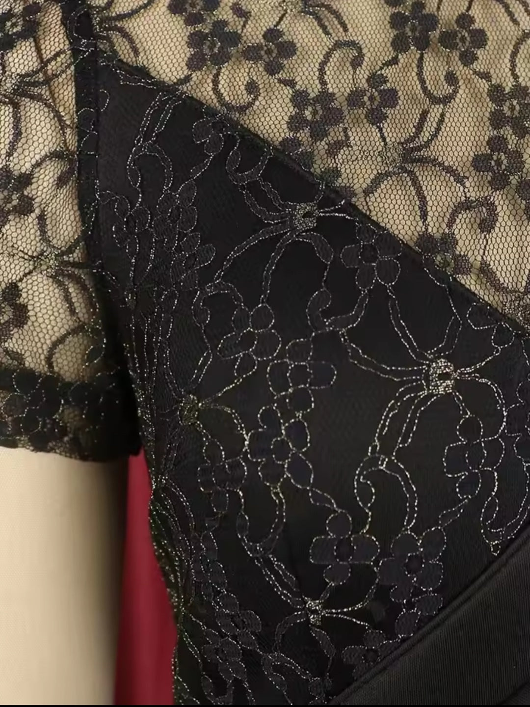 Close-up of black lace fabric with floral patterns on a textured background